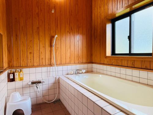 a bathroom with a tub and a toilet at Hamabun テラスでBBQ 湖まで徒歩5分 無料駐車場3台 in Takashima