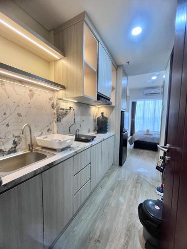 a large kitchen with a sink and a refrigerator at P4 Type Studio Apt Swimming Pool View Batam Centre in Batam Center