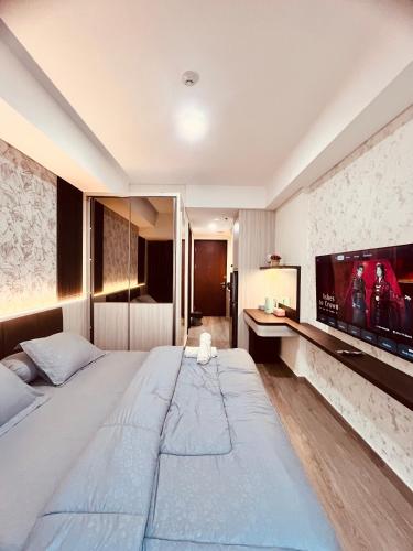 a hotel room with a large bed and a flat screen tv at P4 Type Studio Apt Swimming Pool View Batam Centre in Batam Center