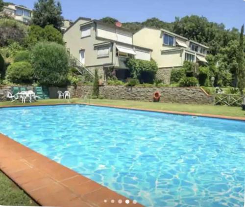 a large swimming pool in front of a house at Cottage Punta Ala Residential Area with Pool in Punta Ala