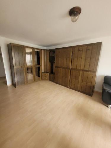 an empty room with wooden cupboards and a couch at Wohnung in Andermatt in Andermatt