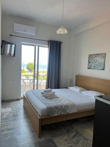 a bedroom with a bed with a view of the ocean at Golden Beach Sea View in Nea Mesangala