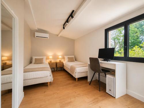 a room with a desk with a computer and a bed at La petite maison in Mougins