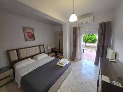 a bedroom with a large bed and a window at Olive Tree Apartments in Parga