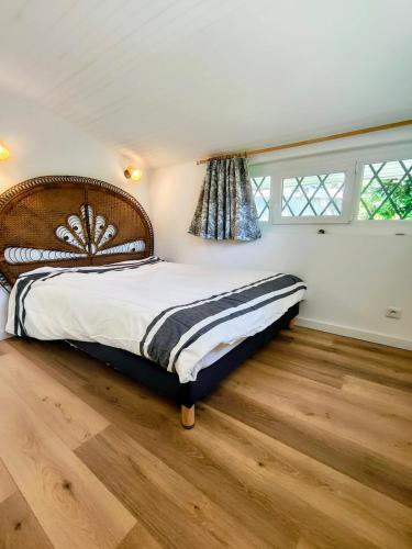 a bedroom with a large bed with a wooden floor at Maison centre ville et lac Hossegor in Soorts-Hossegor