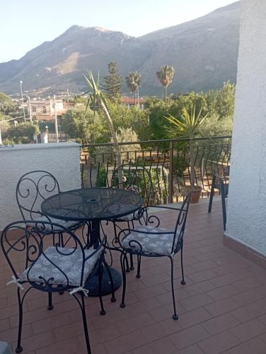 a patio with a table and chairs and a mountain at La Costa del Pavone in Carini