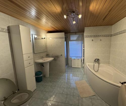 a bathroom with a tub and a toilet and a sink at Logis PONIENTE in Arles-sur-Tech