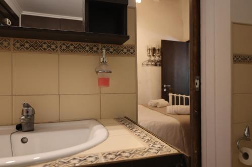 a bathroom with a bath tub and a bed at Angela's River Paradise Cottages in Mixórrouma