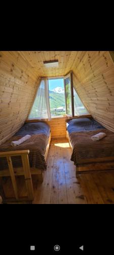 a attic room with two beds and a window at Cottage Irko in Tvebishi