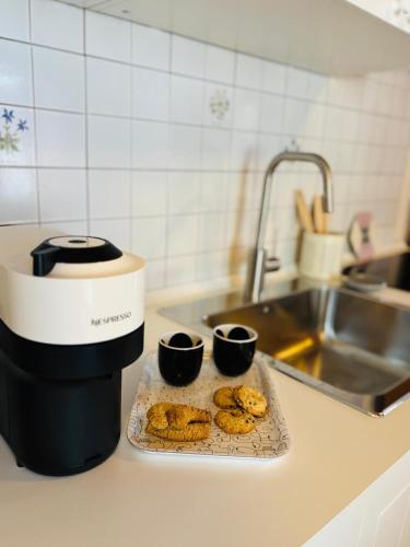 Eine Küchentheke mit zwei Kaffeetassen und Donuts. in der Unterkunft OmniViso in Crissolo