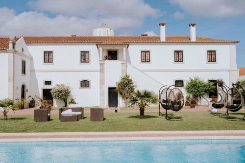a large white house with a pool in front of it at Quinta da Atela in Alpiarça