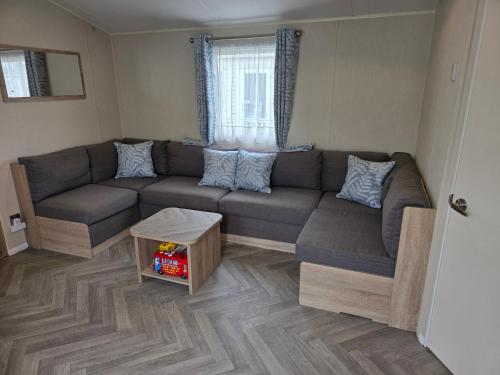 a living room with a couch and a table at Beachside caravan retreat - at New Beach, Dymchurch in Dymchurch