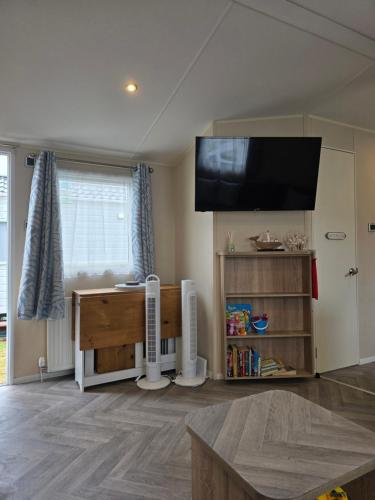 a living room with a flat screen tv on the wall at Beachside caravan retreat - at New Beach, Dymchurch in Dymchurch