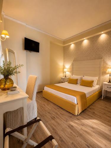 a bedroom with a bed and a desk and a television at Galinio Boutique Apartments in Skafidia
