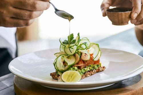 a plate with a sandwich with cucumbers and a spoon at COMO The Halkin in London