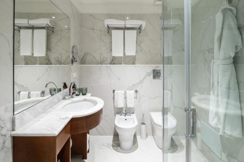 a bathroom with a sink and a toilet and a shower at Palazzo Artemide - VRetreats, an SLH Hotel in Syracuse