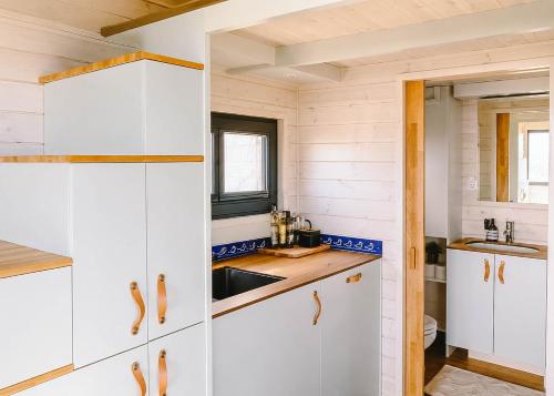 a kitchen with white cabinets and a sink at Tiny Seaside - Skarrev in Aabenraa