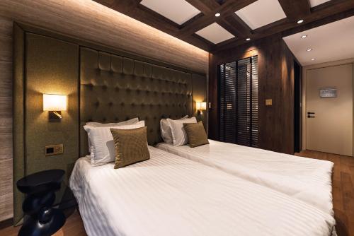 a hotel room with two beds with white sheets at Хотел Дом на Алпиниста in Vratsa