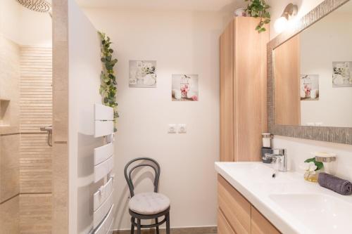 a bathroom with a sink and a mirror and a stool at U Scogliu Escale De Rêve in Poggio-dʼOletta