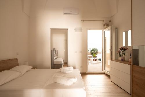 a white bedroom with a bed with towels on it at Sarmalia 32 a pochi passi dal centro di Nardò in Nardò