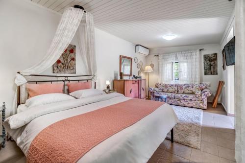a bedroom with a large bed and a couch at Ancient Corinth Guest House in Korinthos