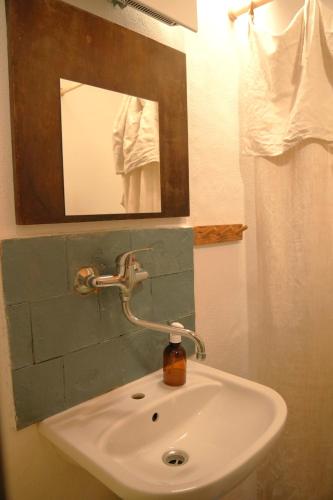a bathroom sink with a mirror and a soap dispenser at Bed&More Almáspuszta in Jestice