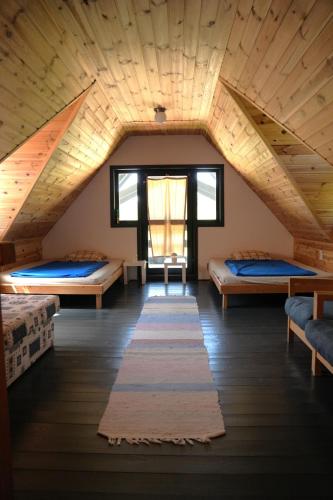 a room with three beds and a wooden ceiling at Bed&More Almáspuszta in Jestice