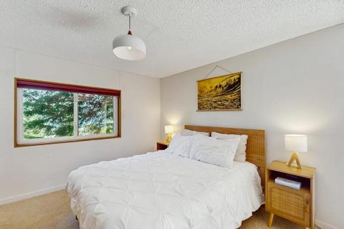 a bedroom with a white bed and a window at Hill House in Belfair