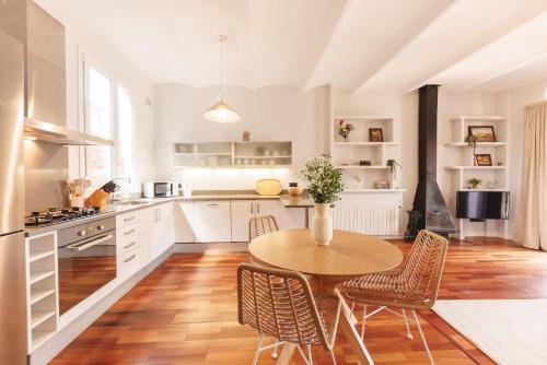 a kitchen with a wooden table and chairs in a room at Bravissimo Nou del Teatre, with panoramic views in Girona
