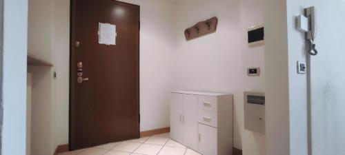 a room with a brown door and a cabinet at Alloggio Maia 2 in Biella