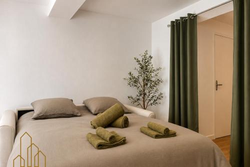 a bed with three pillows on it in a room at L'Échappée du Canal in Roanne
