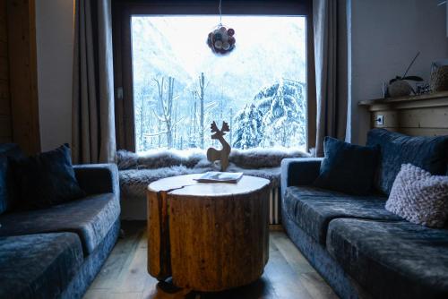 a living room with a table in front of a window at Les Campanules in Les Houches