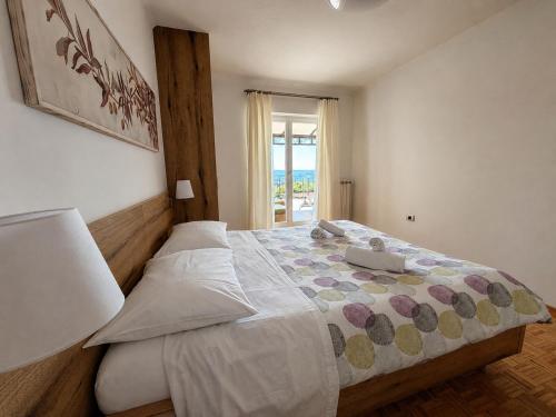 a bedroom with a large bed and a window at Apartment Vrenjak in Portorož