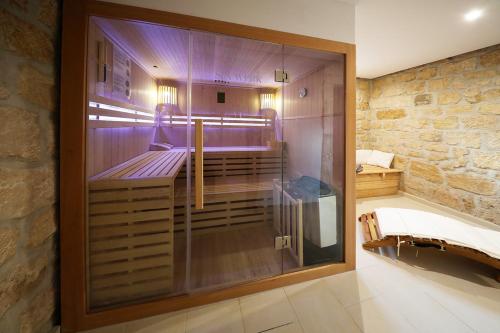 a shower in a bathroom with a stone wall at Haus Felsenpost in Stadt Wehlen