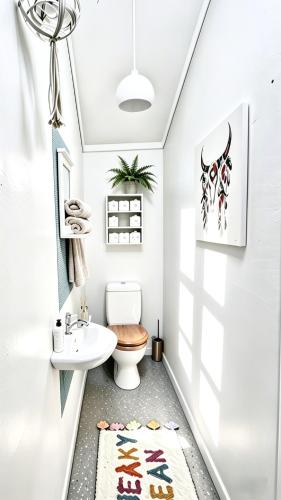 a bathroom with a toilet and a sink at Clifftop Coastal Retreat with Ocean Views - Close to Beach & Cafés in Auckland