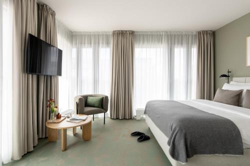 a hotel room with a bed and a chair at Bob W Munich City West in Munich