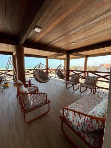 a room with chairs and hammocks on a balcony at Vila Atlântida BEACH FLAT 311B in Luis Correia