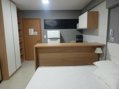 a room with a bed and a desk with a television at Vila Atlântida BEACH FLAT 311B in Luis Correia
