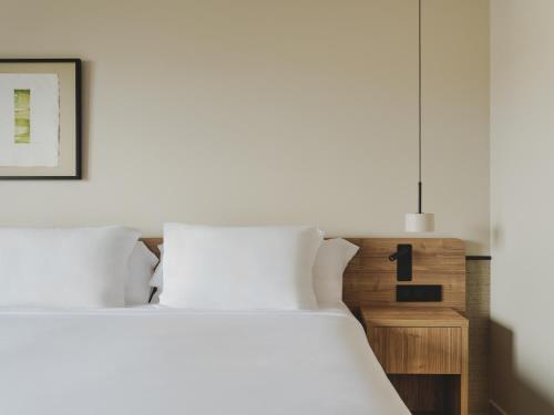 a bedroom with a white bed and a pendant light at Hotel Spa Mediterráneo Park in Roses
