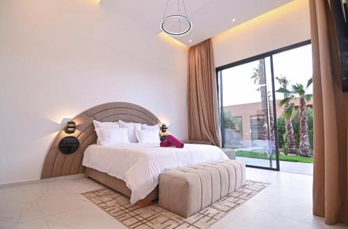 a bedroom with a large bed and a large window at The Oasis Marakech in Marrakesh