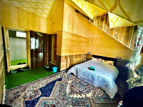 a bedroom with a bed and a large rug at The Riverside Lodge Gulmarg in Gulmarg