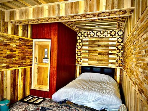 a room with a bed in a wooden room at The Riverside Lodge Gulmarg in Gulmarg