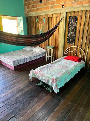 a bedroom with two beds and a mirror at Hostel Bamaica Algodoal - Espaço Curupira in Algodoal