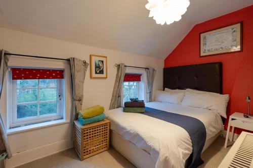 a bedroom with two beds and a red wall at Number Eleven Unique Boutique in Great Gransden