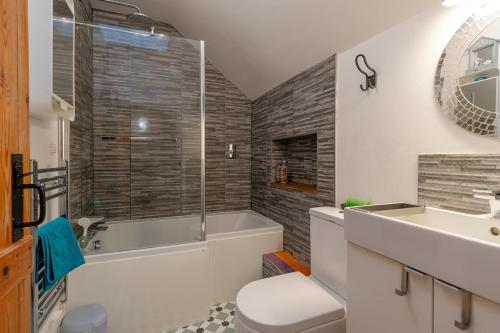 a bathroom with a tub and a toilet and a sink at Number Eleven Unique Boutique in Great Gransden