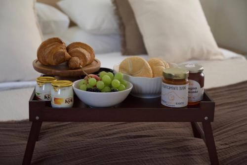 a tray of food with bread and pastries on a bed at Langhem Suites Luxury Apartments in Castiglione Falletto