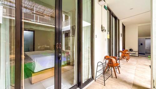 a room with a bed and a glass door at Agung Guest house Canggu in Dalung