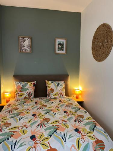 a bedroom with a bed with pillows and two lamps at L'échappée de Bras Long in Entre-Deux
