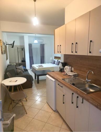 a kitchen and living room with a couch and a table at Olive Tree Apartments in Parga