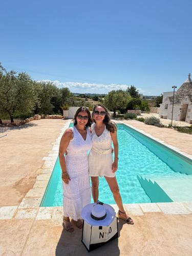 two women are standing next to a pool at Luxury Trulli di Giulia, exclusive villa with private pool in Valle d'Itria Ostuni - BR, Puglia in Ostuni